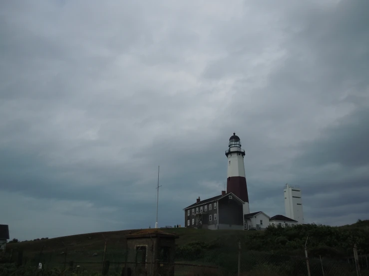 the lighthouse sits atop the hill by the forest