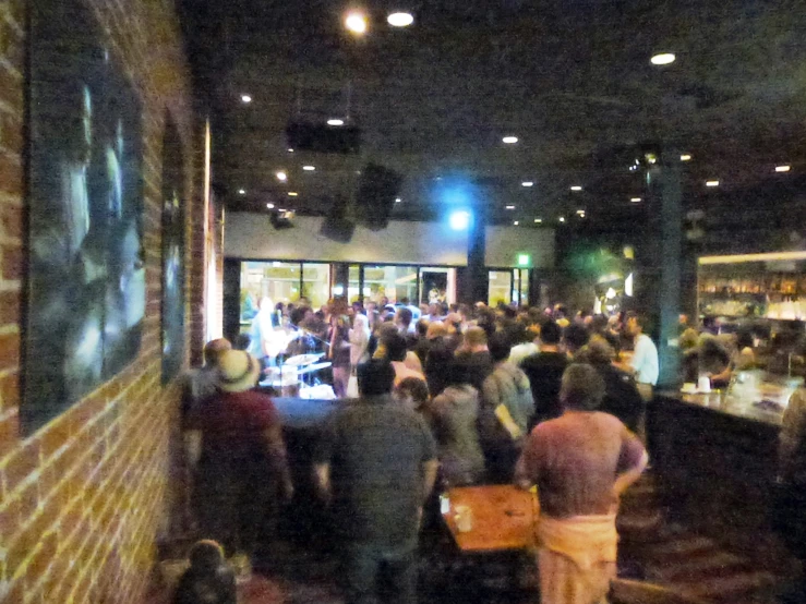 a crowded restaurant with lots of people sitting at tables