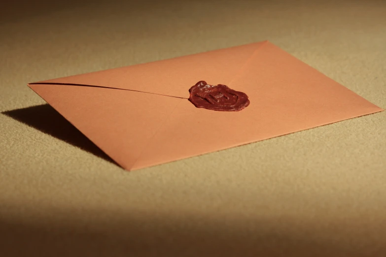 an envelope with a piece of chocolate sitting on it