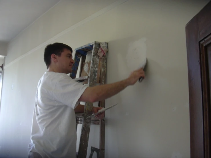 a man with a paintbrush painting a wall