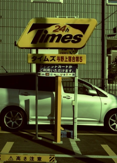 a white car parked under a sign with a yellow frame