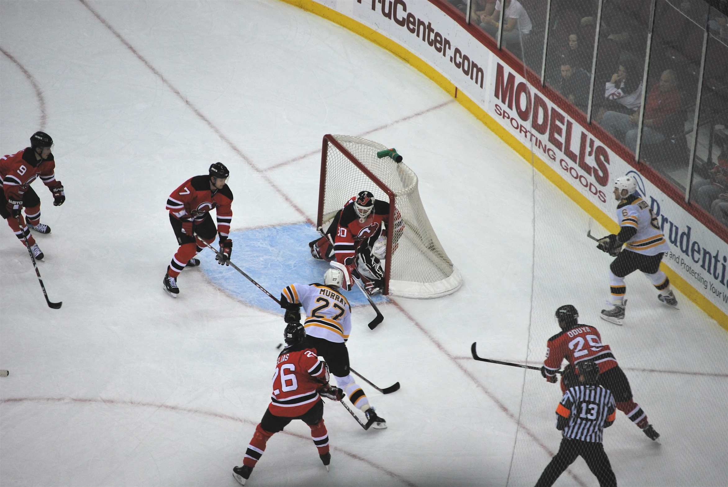 a hockey player holding his stick while watching another play