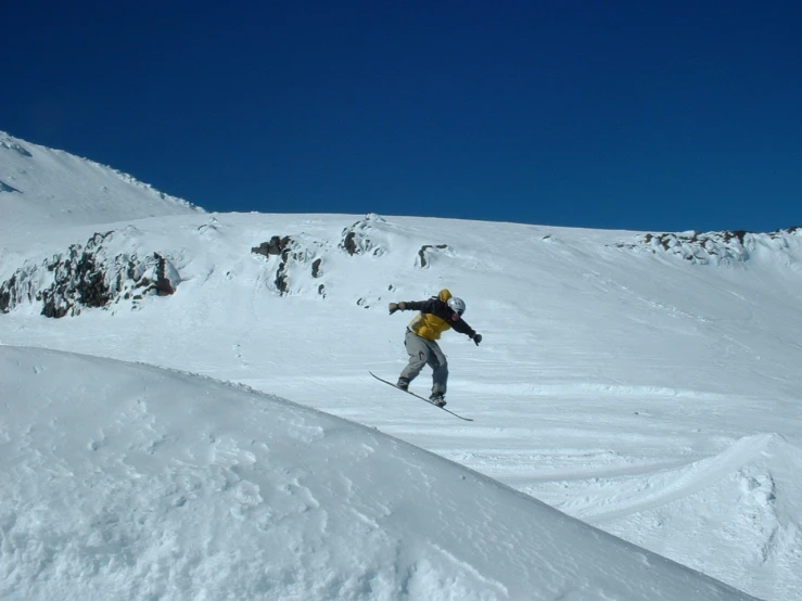 there is a man riding a snowboard down a hill