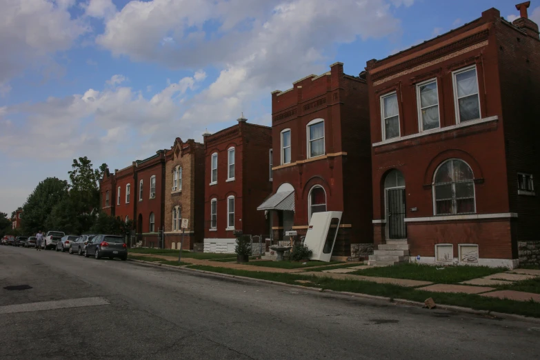 a bunch of old red brick building sitting on the side of a road