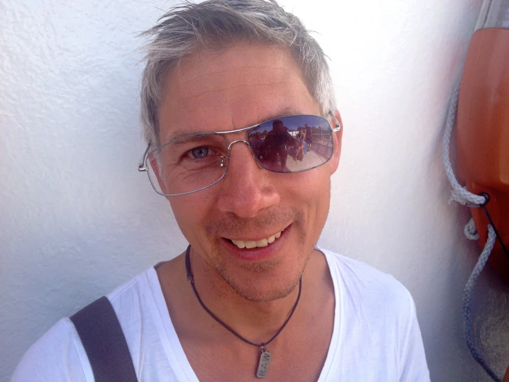 man in white tank top with sunglasses and cers