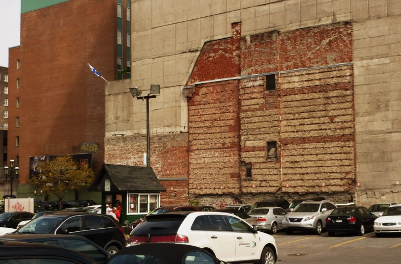 cars are parked in a parking lot with a building in the background