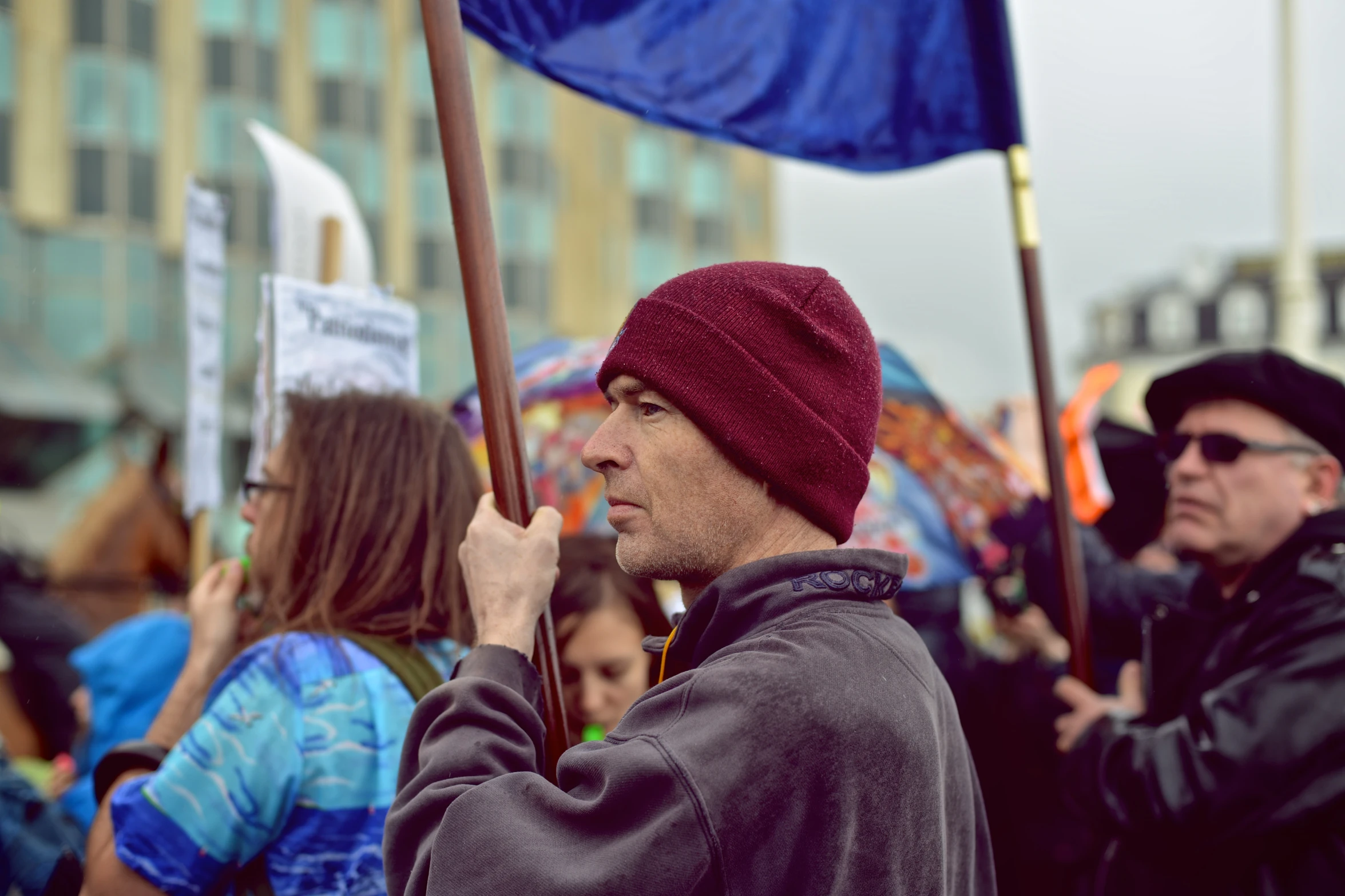 a man holding a blue flag standing next to other people