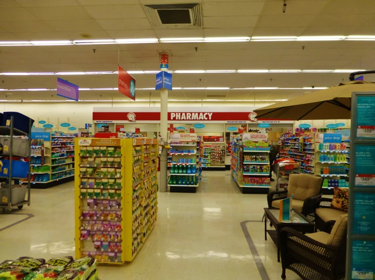 a store aisle with a lounge chair and tables