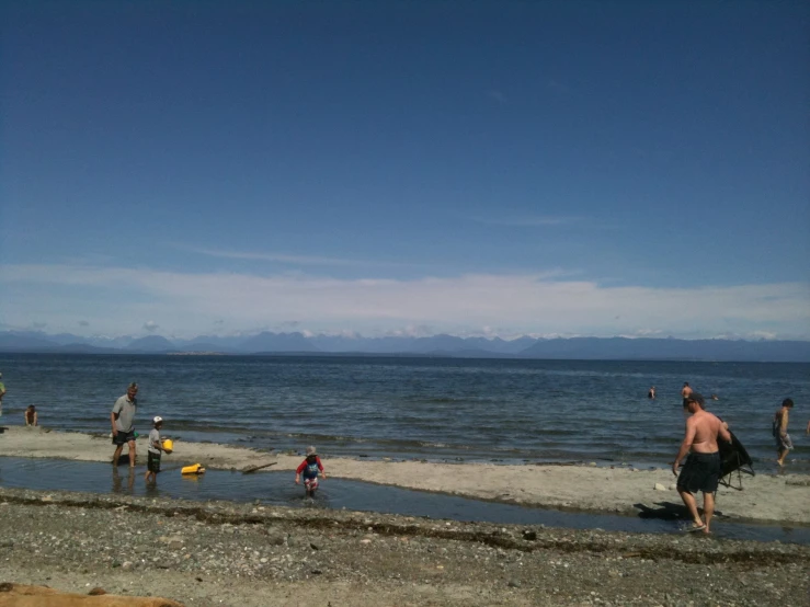 a group of people standing around a body of water