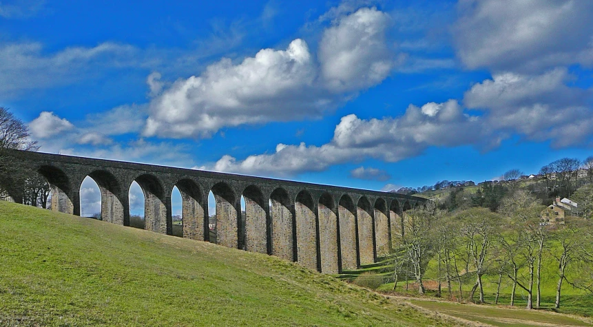 a train travels over the water under the clouds