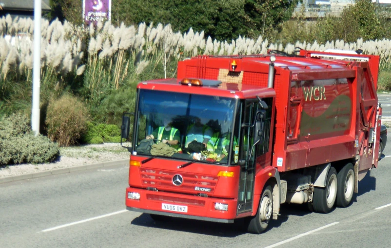 a red truck is traveling on a city street