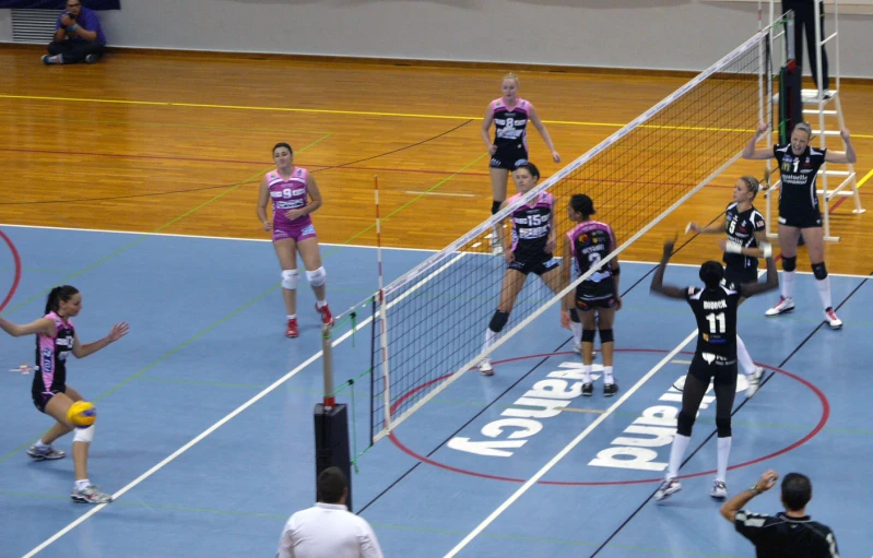 four young women are playing volley ball on a court