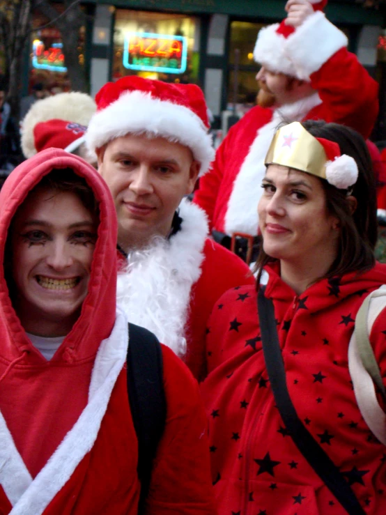 two men and one woman dressed in santa hats and ugly ugly outfits