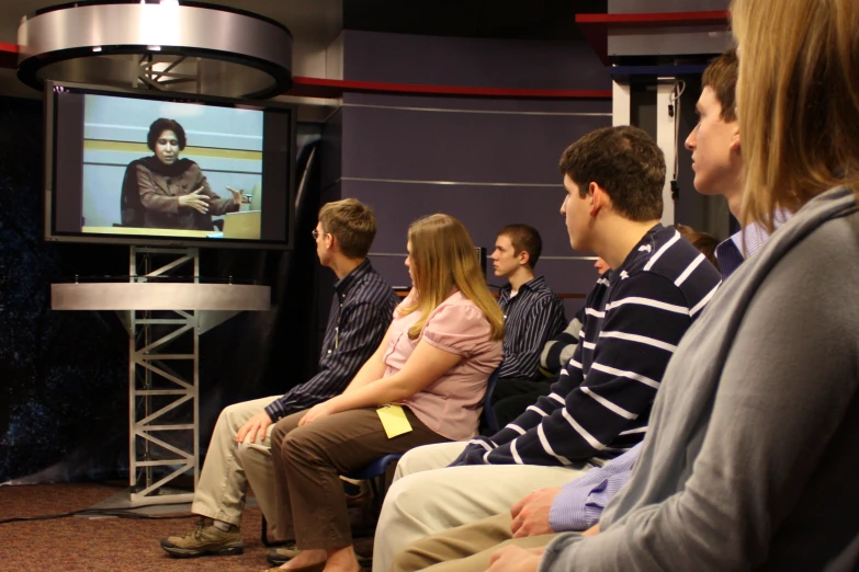 a woman is sitting in front of the screen on tv