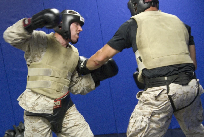 two men wearing safety gear with one wearing boxing gloves