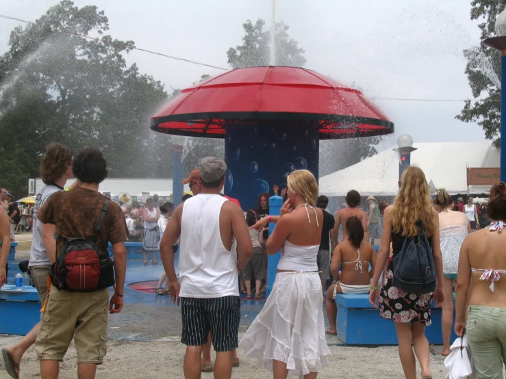 a group of people standing around a fountain