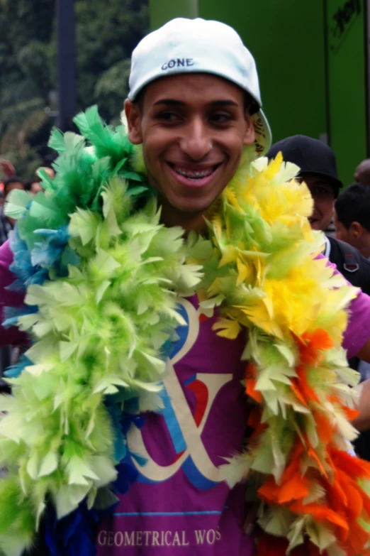 guy smiling and wearing some very colorful stuff around his neck