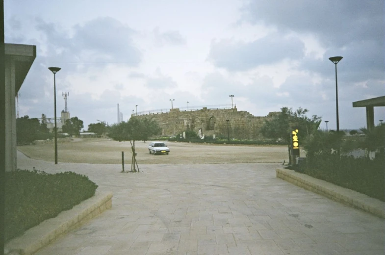 a car is parked outside the gated entrance to an abandoned building