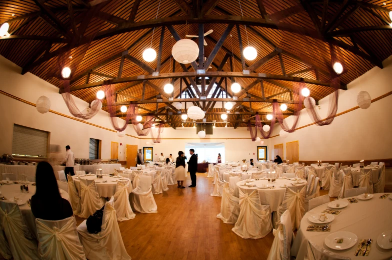 a large, white banquet room with decorated tables and chairs