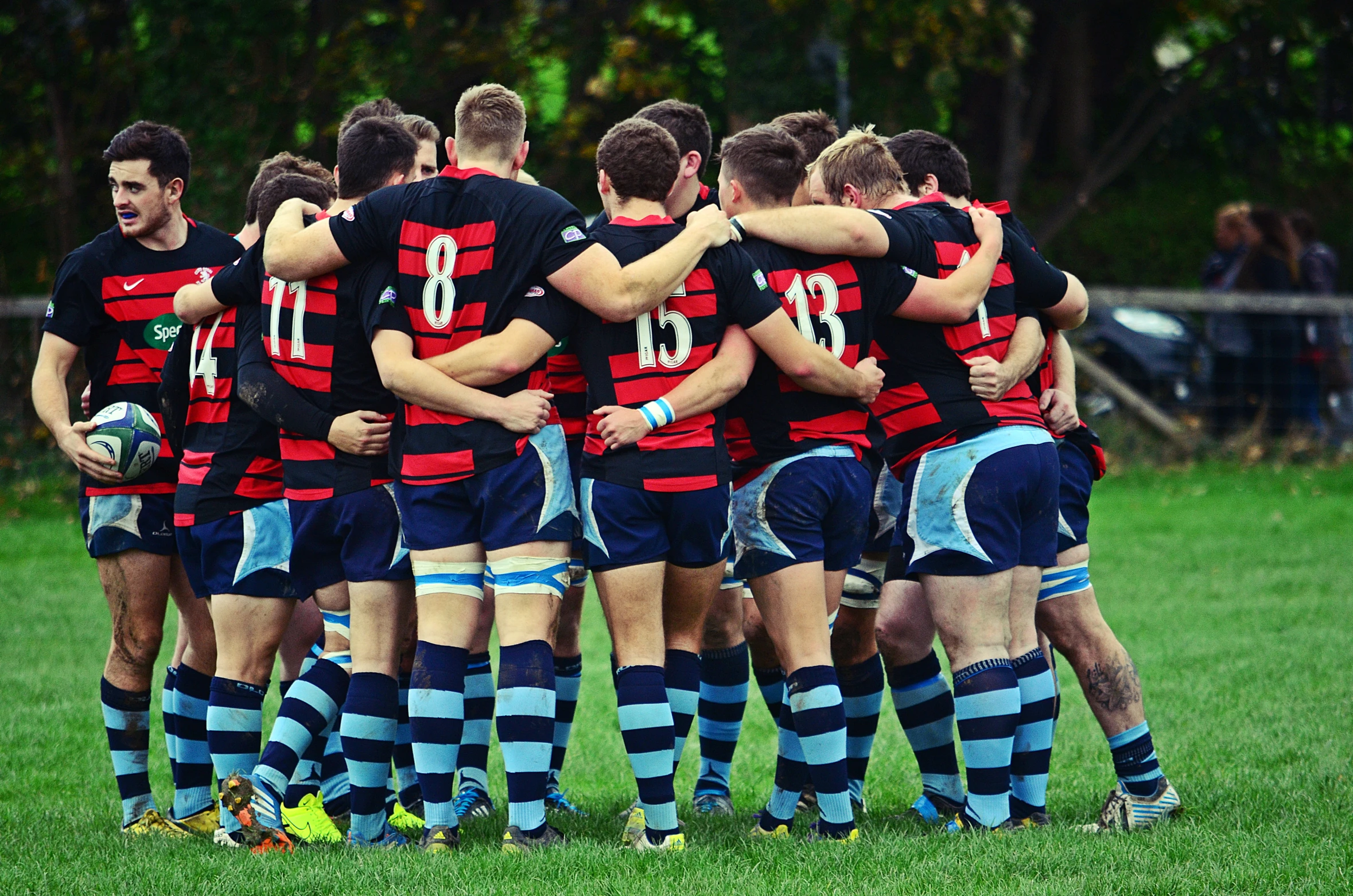 soccer team huddled in a huddle on green grass