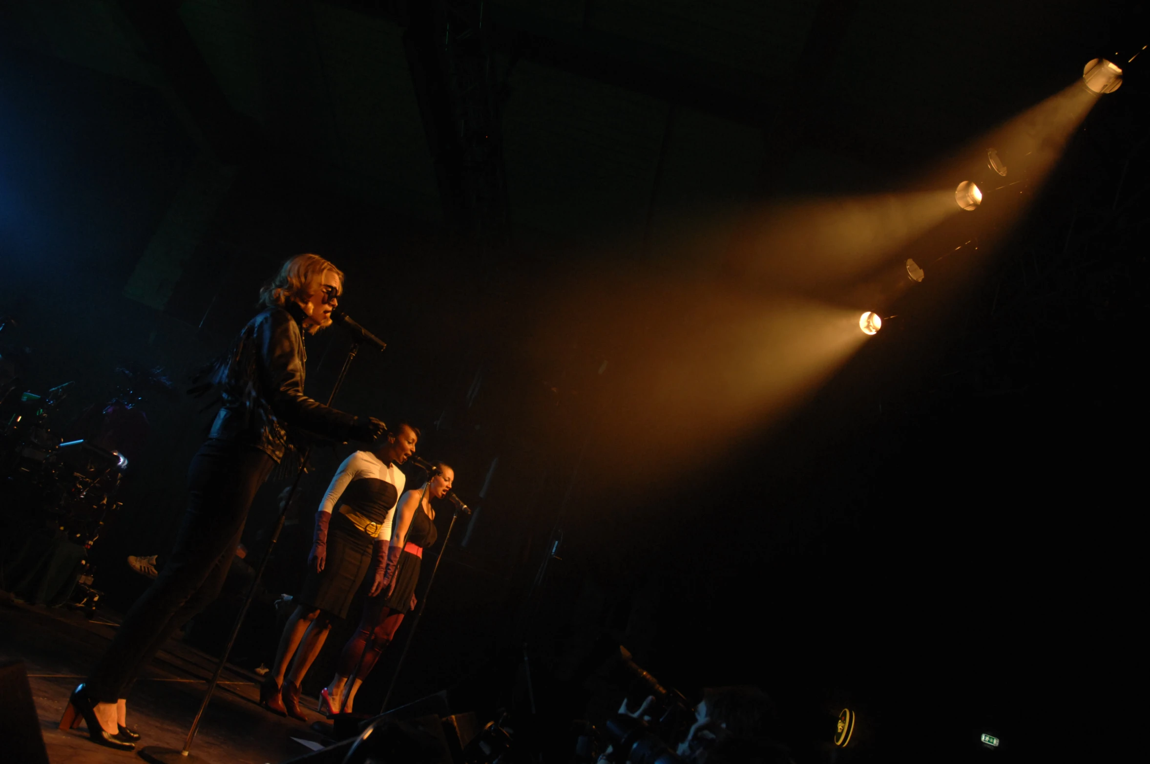 a man singing into microphone in front of other people