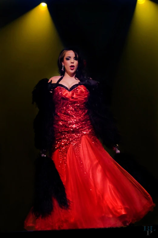 a woman with a red dress standing under a spotlight