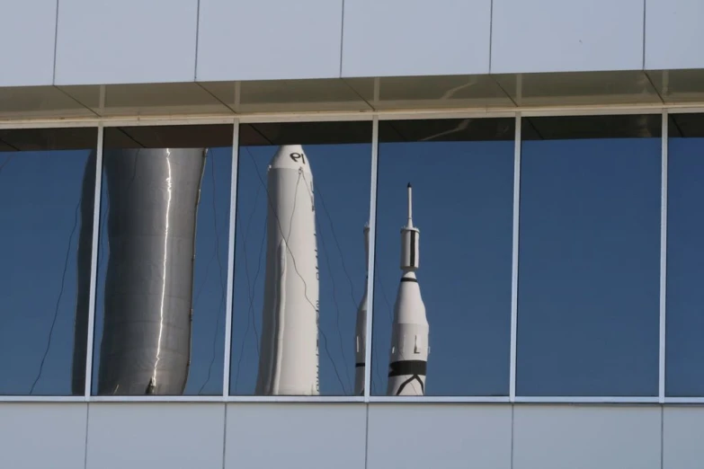 several different sized rockets sit behind glass in the foreground