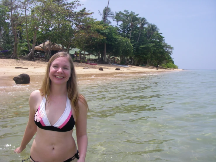 girl in black and white bikini smiling on the beach