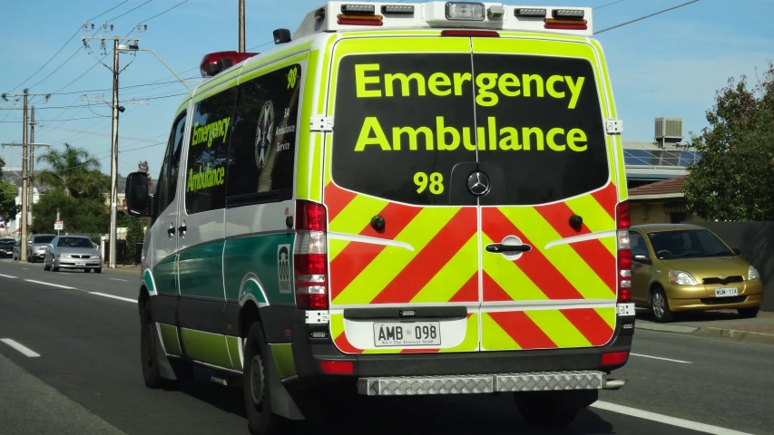 the back of an ambulance that is driving down a street