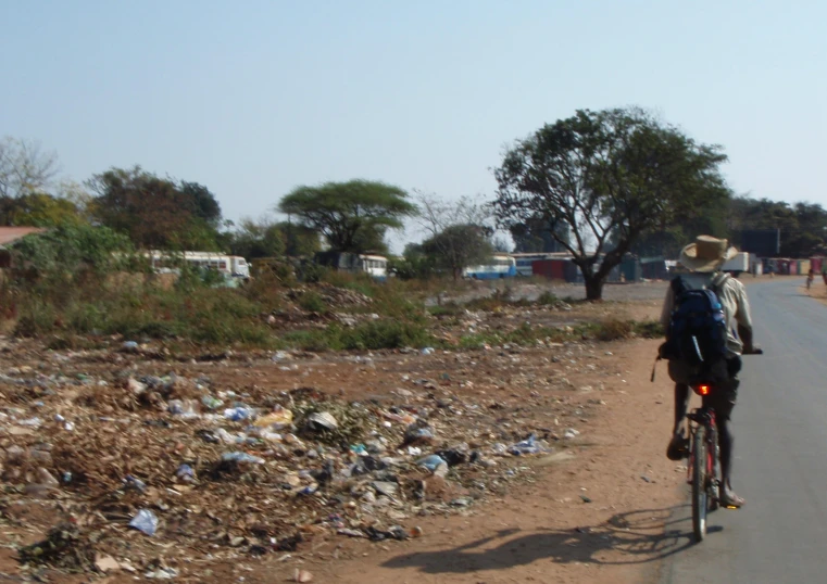 a man riding a bike down a dirt road