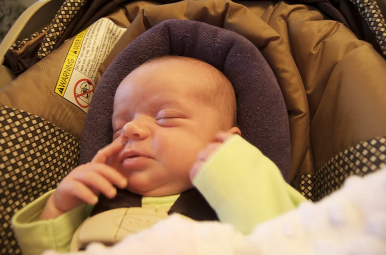 a newborn baby boy in a stroller looking up