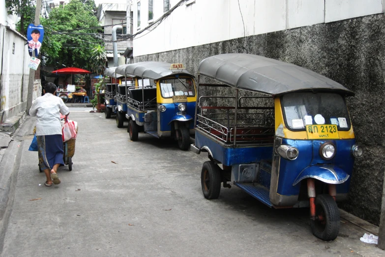 three wheeled asian trucks parked on a street