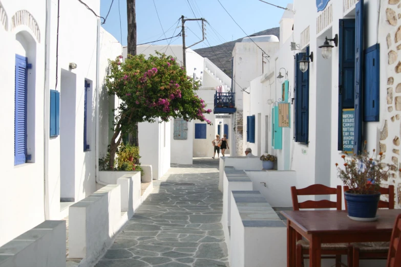 a street with people walking down it next to white buildings