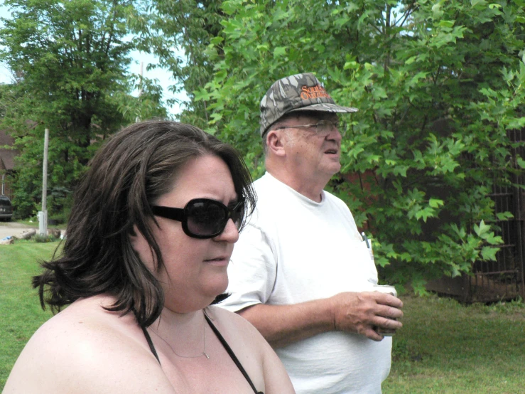 a man and woman standing together outside on a cloudy day