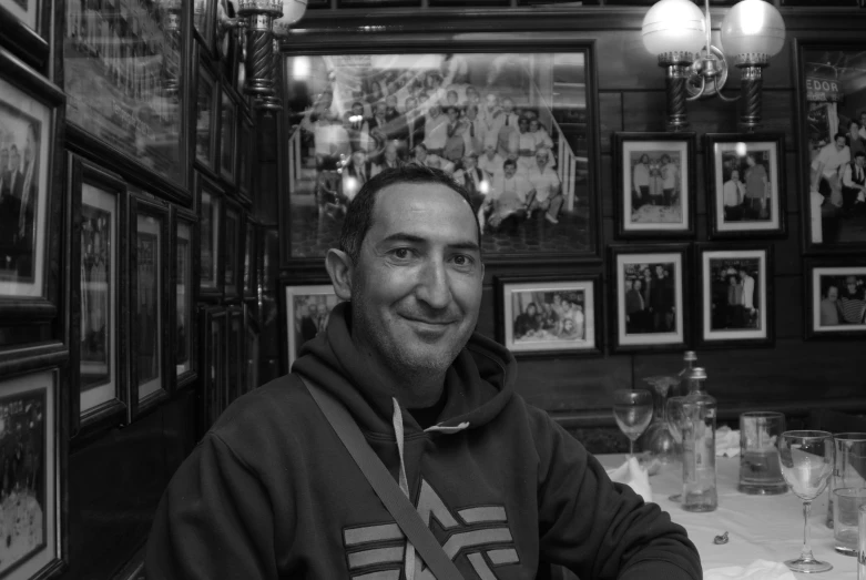 a man sitting at a table with two empty wine glasses in front of him