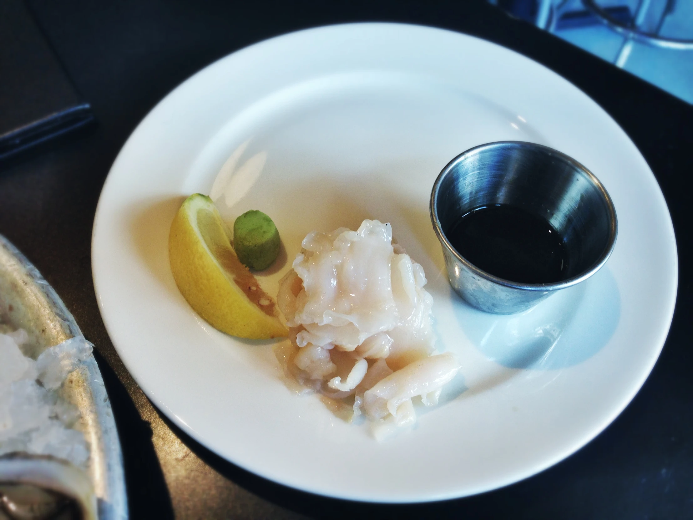 plate on the table with an olive and some lemon wedges and a spoon