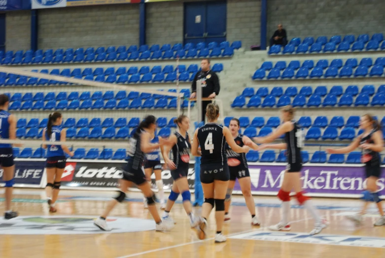 women playing volleyball in a big arena