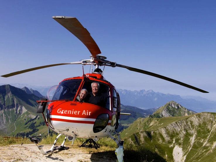 a man and a woman sit in the front of a helicopter