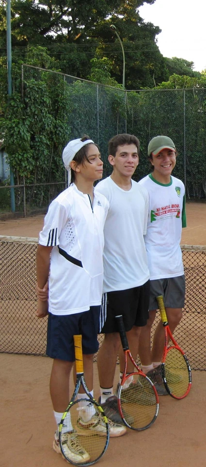 a group of young people posing for a po with tennis rackets