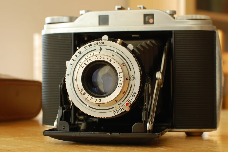 an old vintage camera on the table looking pretty