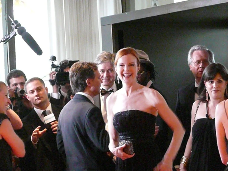 the actor in a black strapless dress is surrounded by pographers