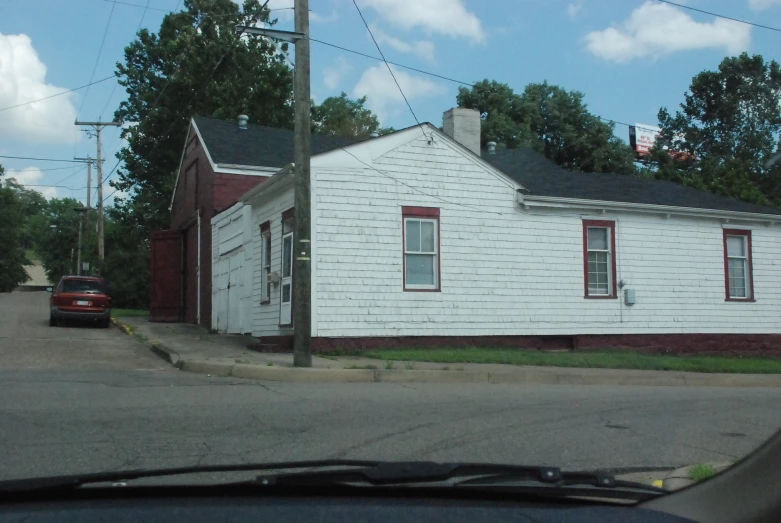 a white house on the corner of an empty street