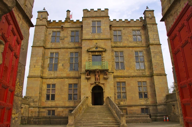 a tall brown building with several doors and some steps