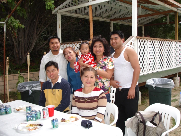 a family gathered around the table eating outside