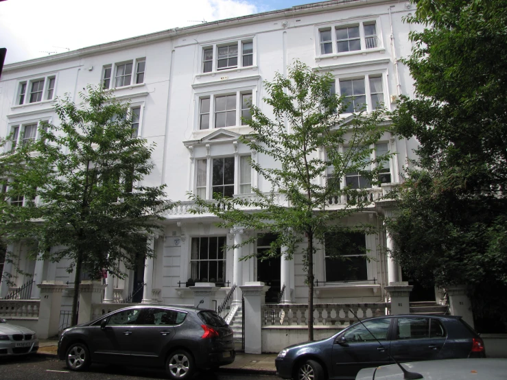 a white building with several cars parked on the street