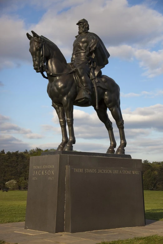 a statue is set on a pedestal in the middle of a field