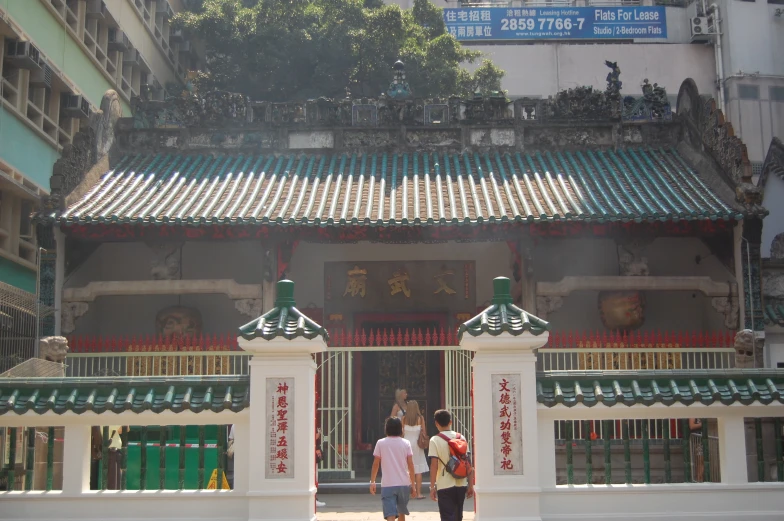 two people standing near the entrance to an asian temple