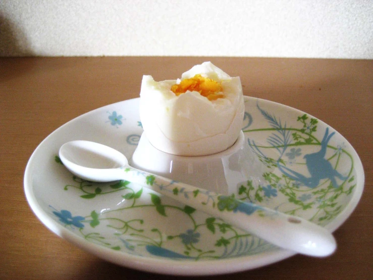 an open egg with some cream on it and spoons