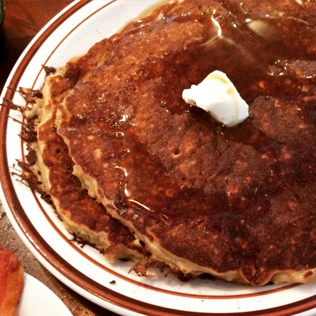 two pancakes covered in chocolate syrup on a white plate