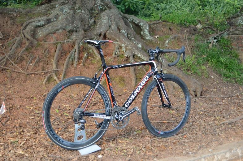 a bike sitting in the dirt in front of a tree